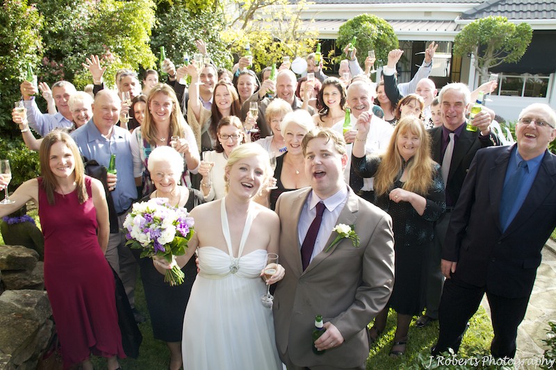 Bride and groom cheering with all guests - wedding photography sydney